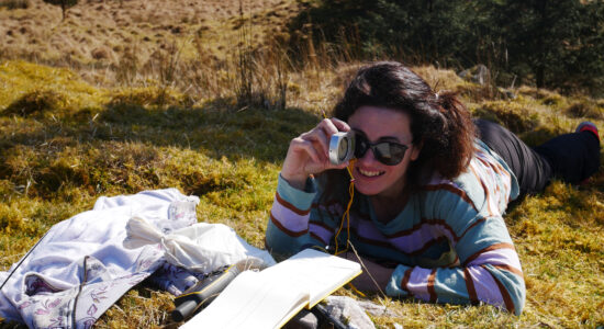 A photo of a woman in the field lying on the grass