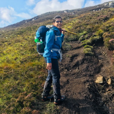 photo of a woman on a hill in field gear