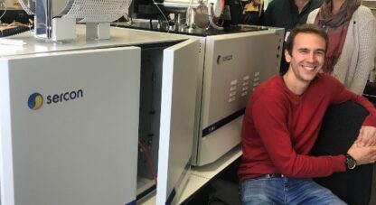 Photo of four people stood next to lab machines